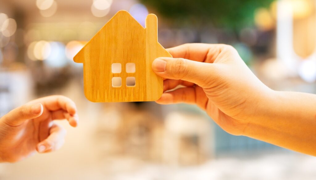 Adult,Hand,Giving,Wooden,House,Model,To,Childs,Hand.,Symbol