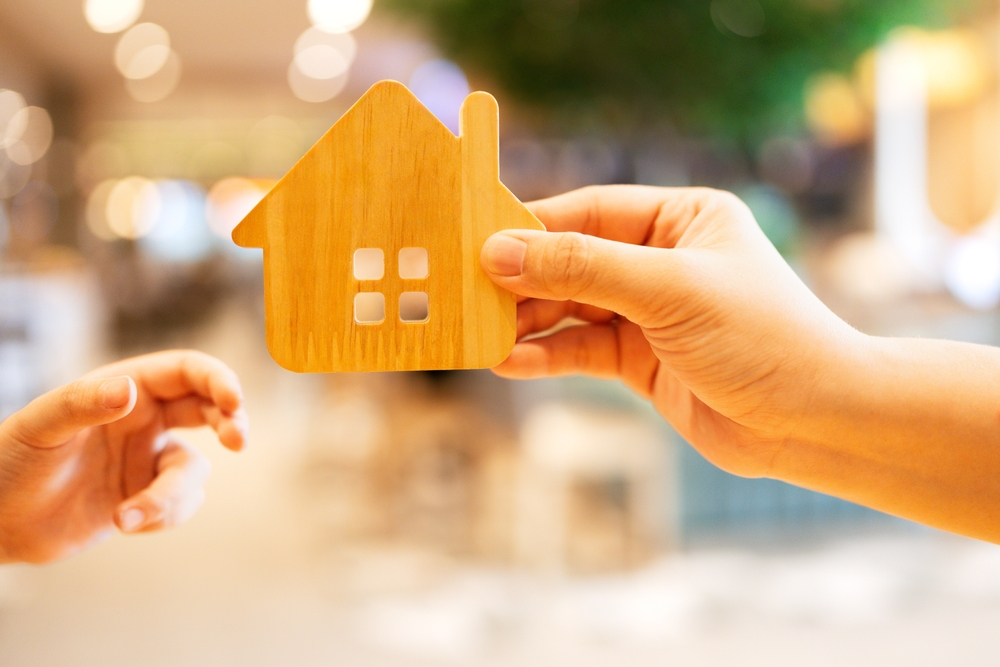 Adult,Hand,Giving,Wooden,House,Model,To,Childs,Hand.,Symbol Bond and transfer costs explained — the full cost of buying a home