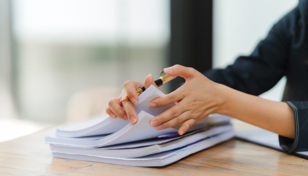 Businesswoman,Reviewing,Documents:,A,Close-up,Of,A,Businesswoman's,Hands,Meticulously