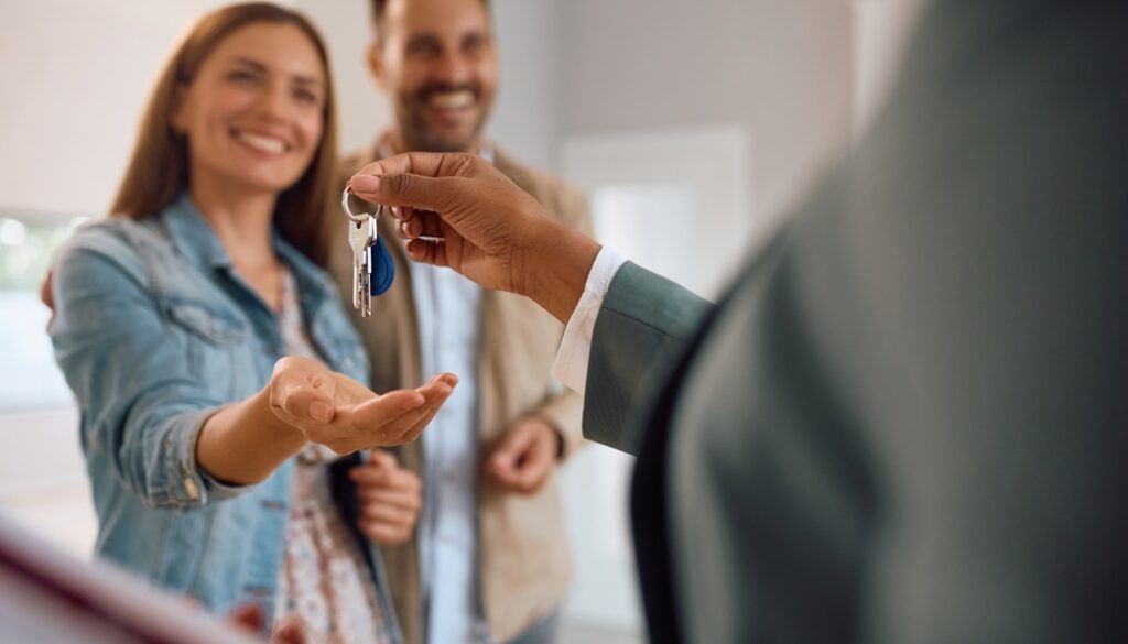 Close,Up,Of,Happy,Couple,Receiving,Keys,Of,Their,New
